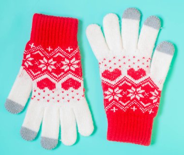 warm winter gloves on mint background.