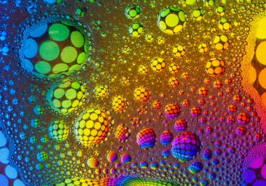 Suyun üzerinde yüzen yağdan yapılan çok renkli gökkuşağı efekti psikedelik soyut arka plan .