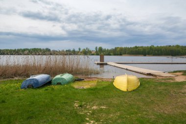 Limbazi gölünde bir tekne ve tahta köprü. .