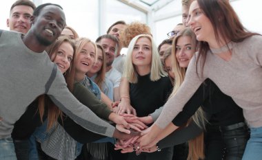 Kapat. Çeşitli gençler ellerini birleştiriyor.
