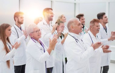 Bir grup tıbbi pratisyen birlikte alkışlıyor. Başarı konsepti