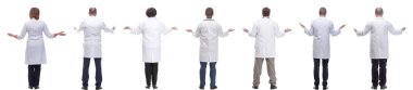 Sırtları beyaz arka planda izole bir şekilde duran bir grup doktor.