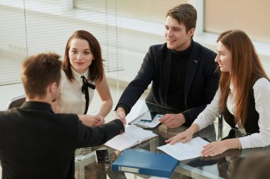 Mutlu iş ekibi ofiste ayakta alkışlıyor. Başarı kavramı.