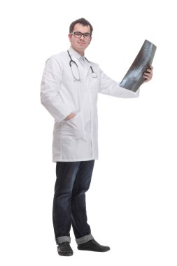 Front view of hospital doctor holding patients x-ray film and lookind at it