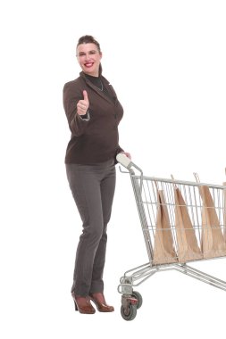 Alışveriş arabalı genç bir kadın kameraya bakıyor.