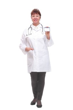 Kıdemli kadın doktor beyaz arka planda kartvizit gösteriyor ve kameraya bakıyor.