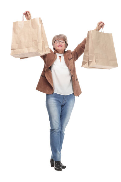 Side view full length portrait of a Senior woman walking with shopping bags. Concept of happy shopping