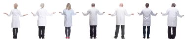 Sırtları beyaz arka planda izole bir şekilde duran bir grup doktor.