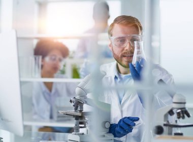 Laboratuvarda çalışan odaklanmış erkek bilim adamı