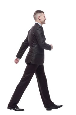 Tam gelişim. Genç işadamı kendinden emin adımlarla ilerliyor. beyaz arkaplanda izole edilmiş.