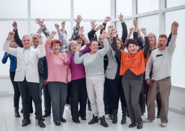 Zafere sevinmek için ellerini kaldıran bir grup insan.