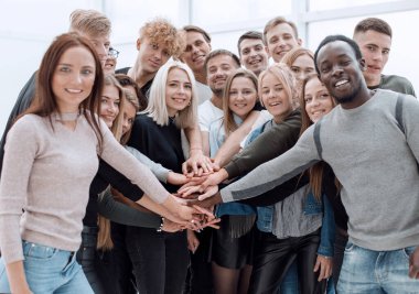 Kapat. Bir grup genç insan ellerinden kule yapıyorlar..