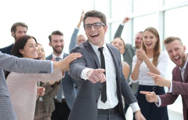 Neşeli iş adamı iş adamlarının önünde duruyor ve seni işaret ediyor.