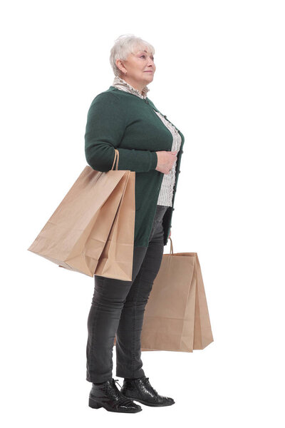 Smiling senior woman with shopping bags over white background. Sale and old people concept