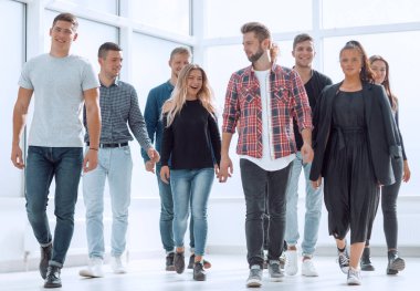 Tam gelişim. Bir grup mutlu genç çalışan yeni bir ofise giriyor.