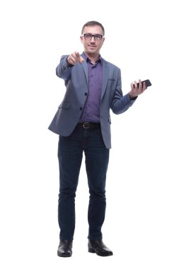 Beyaz arka planda akıllı telefonunu kullanan yakışıklı genç adam kameraya bakıyor.