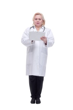 Beyaz önlük giyen ve dijital tablet kullanan kadın doktor ciddi bir ifadeyle ekrana bakıyor.