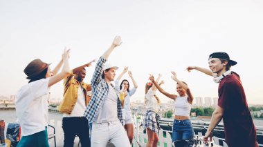 Yavaş hareket rahatlatıcı ve having fun ile gülüyor ve karıştırma konsolu kullanarak deejay çatı üzerinde dans kadın ve çekici genç erkek. Parti, gençlik ve dostluk kavramı.