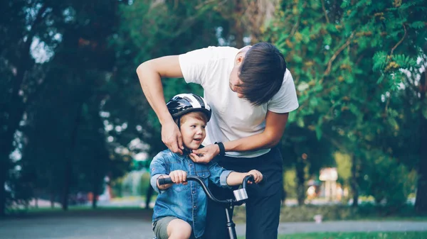 Pai Carinhoso Está Colocando Capacete Segurança Sua Cabeça Filhos Pequenos — Fotografia de Stock