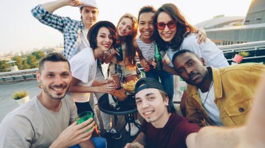 Bakış açısı shot çekici genç erkek ve kadın selfie şişe ile alarak alkolsüz içecekler, içme ve komik suratlar ile poz zevk. Modern yaşam tarzı ve içecek konsepti.