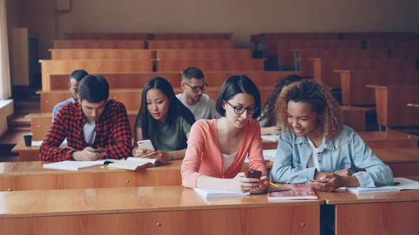 Ungdomar Använder Smartphones Och Pratar Sitter Vid Skrivbord Föreläsningssalen Universitet — Stockfoto