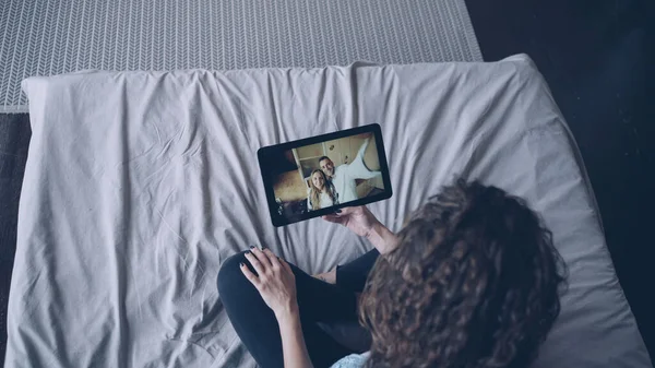 年轻的女士正在网上与美丽的夫妇交谈 平板电脑看屏幕和谈话坐在家里的床上 现代科技 对话与快乐青年观 — 图库照片