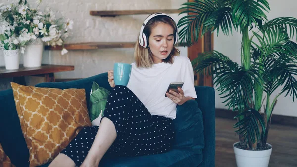 Moderní Mladá Žena Odpočívá Pohodlné Pohovce Doma Smartphone Šálek Čaje — Stock fotografie