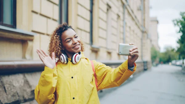 아프리카 미국인 소녀가 스마트폰을 화면을 보면서 비디오 전화를 말하고 즐거운 — 스톡 사진