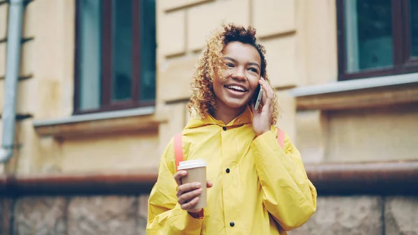 Беззаботная Афроамериканка Разговаривает Телефону Держит Руках Кофе Открытом Воздухе Современном — стоковое фото
