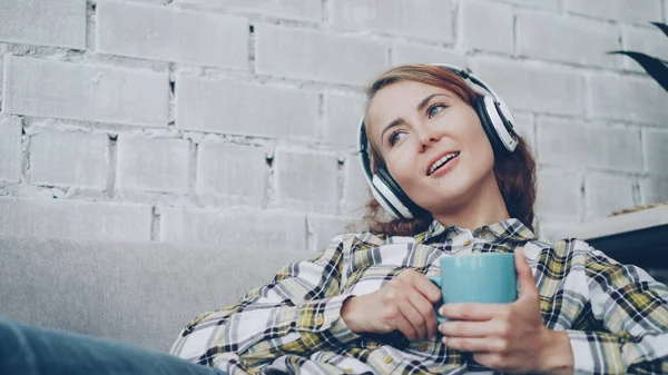 Entspannte Studentin Hört Lieblingsmusik Mit Kopfhörern Singt Und Hält Tasse — Stockfoto