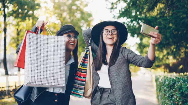 Unbekümmerte Mädchen Machen Mit Smartphones Selfies Posieren Mit Einkaufstüten Auf — Stockfoto