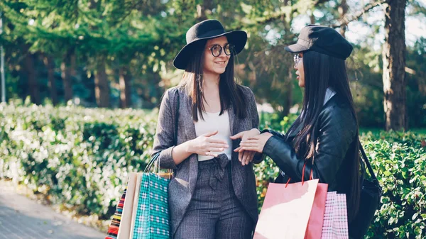 迷人的亚洲女孩正在和她的朋友在街上抱着购物袋 笑着说 现代城市与购物狂概念 — 图库照片