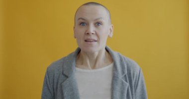 Genç bir kadının dilek tutması ve sarı arka planda dua etmesi. Umut ve insan ifadesi kavramı.