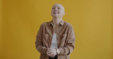 Sarı arka planda eğlenen neşeli genç kızın portresi. Olumlu duygular ve modern gençlik ifadeleri kavramı.