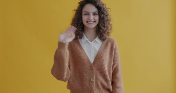 Mutlu Genç Bir Kadının Portresi Sallıyor Gülümsüyor Sarı Arka Plandaki — Stok video