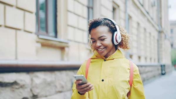 Chica Afroamericana Feliz Está Escuchando Música Través Auriculares Inalámbricos Uso — Foto de Stock