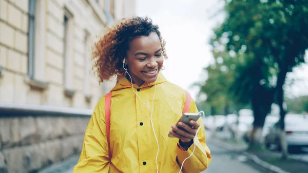 아프리카계 미국인 이어폰을 음악을 스마트폰 도시에서 거리를 재미와 가제트 — 스톡 사진