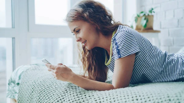 Vonzó Fiatal Hölgy Használ Smartphone Ágyon Otthon Képernyő Megérintésével Mosolygott — Stock Fotó