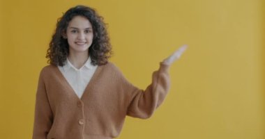 Yan tarafı gösteren genç bayanın portresi içeriğe dikkat çekiyor ve sarı arkaplana doğru gülümsüyor. İnsanlar ve reklam kavramı.
