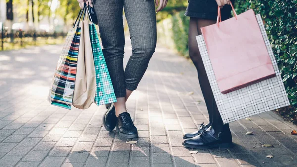 低角度拍摄的女性腿站在人行道上举行丰富多彩的购物袋后 在商店和商场的快乐繁忙的一天 消费主义与休闲理念 — 图库照片