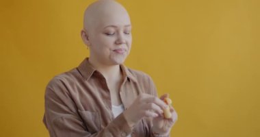 Kablosuz kulaklık kullanan, dans eden ve sarı arka planda gülümseyen kaygısız öğrenci portresi. Modern teknoloji ve gençlik yaşam tarzı kavramı.