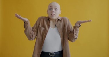 Heyecanını ifade eden duygusal kızın yavaş çekim portresi şaşırmış ve mutlu bir şekilde sarı arka planda duruyor. Olumlu duygular ve mutluluk kavramı.