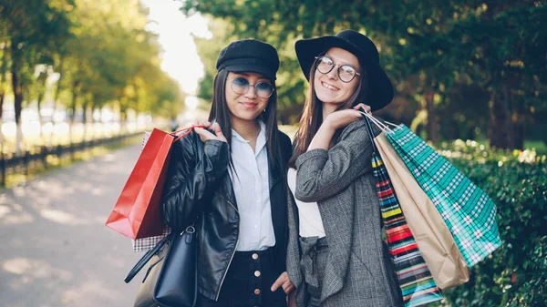 美丽的年轻女性的画像站在街上拿着纸袋 微笑着看着相机 青年生活方式 友谊与消费观念 — 图库照片
