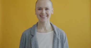 Mutlu kadın portresi tamam el hareketi yapıyor ve gülümsüyor sarı arkaplana karşı memnuniyetini ifade ediyor. İnsanlar ve duygu kavramı.