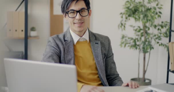 デスクに座っている若いアジア人ビジネスマンのスローモーションの肖像画 ビジネスマンと職場のコンセプト — ストック動画