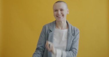 Neşeli kadın portresi sarı arka planda tek başına müzik dinlerken eğleniyor. Eğlence ve eğlence zamanı konsepti.