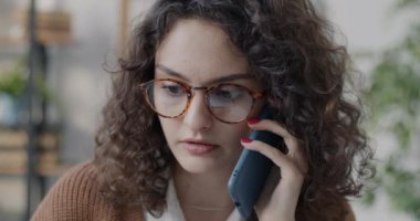 Kadın ofis çalışanının yakın plan portresi cep telefonunda müşteriye danışmanlık yapıyor tek başına çalışıyor ve gülümsüyor. İnsanlar ve iletişim konsepti.