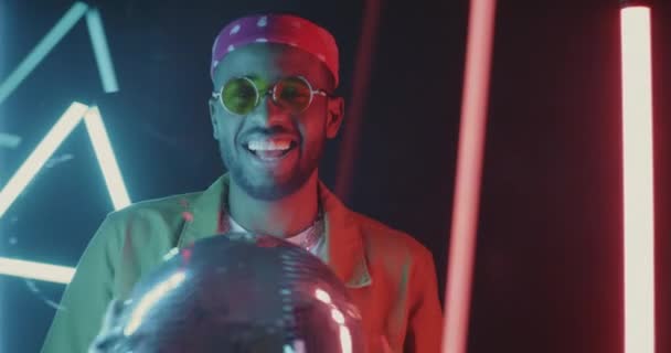Neon Lambaların Arkasında Disko Topuyla Dans Eden Yakışıklı Afro Amerikan — Stok video