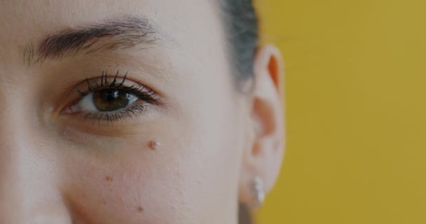 在黄色背景下 女性与年轻女性在眼皮底下涂上乳霜的特写 皮肤护理和化妆品概念 — 图库视频影像