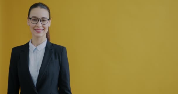 Retrato Bela Jovem Empresária Apontando Para Lado Sorrindo Fundo Amarelo — Vídeo de Stock